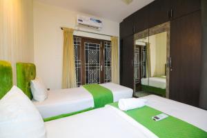 a bedroom with two beds and a mirror at Nestoa Suites - Benson Town in Bangalore