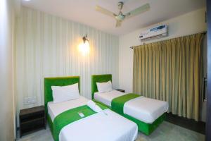 two beds in a room with green and white at Nestoa Suites - Benson Town in Bangalore
