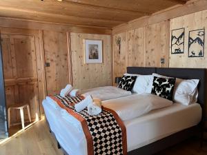 a bed in a room with wooden walls at Sonne in Klosters