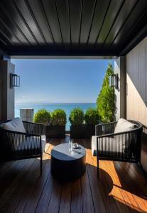 a patio with two chairs and a table on a deck at Coral Hotel Athens in Athens