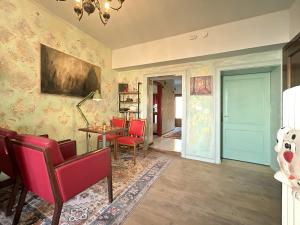 a living room with red chairs and a table at Villa della Comare in Osigo