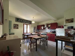 a kitchen with red cabinets and a table and chairs at Villa della Comare in Osigo