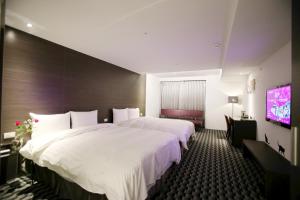 A bed or beds in a room at Chiayi Look Hotel