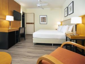 a hotel room with a bed and a tv at NH Bariloche Edelweiss in San Carlos de Bariloche