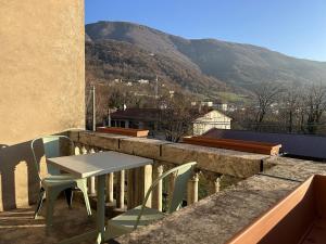 a table and chairs on a balcony with a mountain at Villa della Comare in Osigo