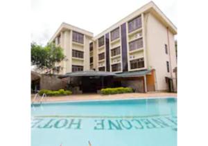 un edificio con piscina en frente de un edificio en The Pinecone Hotel Kisumu, en Kisumu