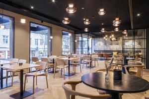 a restaurant with tables and chairs and windows at Scandic Victoria Florø in Florø