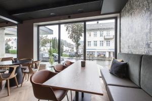 a restaurant with a table and chairs and a large window at Scandic Victoria Florø in Florø