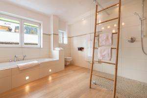 a bathroom with a shower and a tub and a toilet at Alpenhof Wängle in Reutte +54 photos