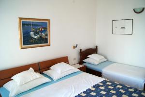 a bedroom with two beds and a painting on the wall at Apartmani Braco Caratan in Zavala