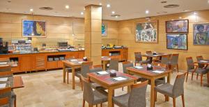 a restaurant with wooden tables and chairs and a counter at NH Sport in Zaragoza