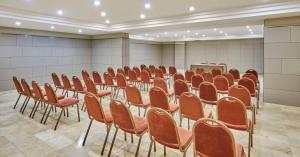 una sala con filas de sillas y un podio en iStay by NH Zaragoza Sport Hotel, en Zaragoza