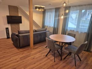 a living room with a couch and a table and chairs at FeWo Zenk Stublang in Bad Staffelstein