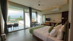 een slaapkamer met een groot bed en een groot raam bij Veera Resort in Attigundi