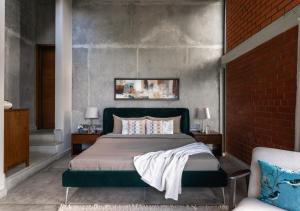 a bedroom with a bed and a brick wall at LohonoStays Amani Villa 10A in Coonoor +39 photos