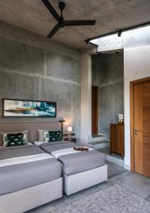 a bedroom with two beds and a ceiling fan at LohonoStays Amani Villa 10A in Coonoor