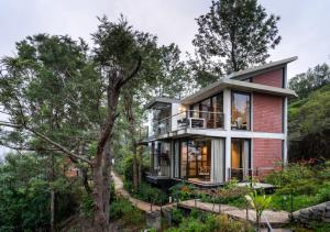 a house on a hill with trees at LohonoStays Amani Villa 10A in Coonoor