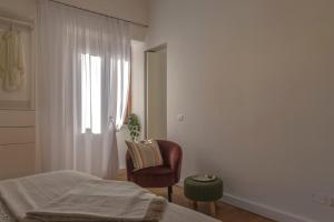 a bedroom with a bed and a chair and a window at Maison 161 in Rieti