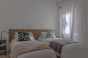 two beds in a room with a window at Maison 161 in Rieti