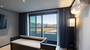 a room with a bed and a large window at 대전 유성 낙원온천호텔 by 아늑 in Yusŏng +98 photos