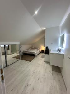 a white room with a bed and a mirror at Appartement cosy 2 chambres in Jougne +7 photos