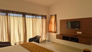 科代卡纳尔Banana Tree Retreat的一间配有床和电视的酒店房间 更多118张照片