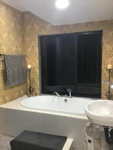 un baño con bañera y lavabo en Hooggelegen Estate, en White River 26 fotos más