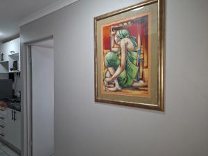 a painting on a wall of a woman looking in a mirror at Grace Villas 1 in East London +25 photos