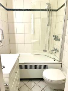 un bagno bianco con doccia e WC di Strandbude 33 a Heiligenhafen