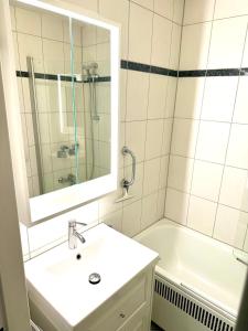 un bagno con un lavandino, una vasca e uno specchio di Strandbude 33 a Heiligenhafen