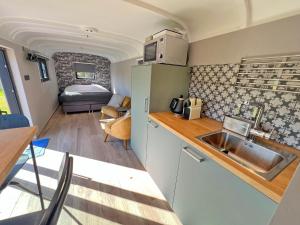 a kitchen with a sink and a room with a bed at Pine Tree Tiny cottage in Rochefort +25 photos