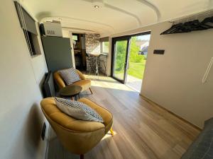 a living room with a couch and chairs in a house at Pine Tree Tiny cottage in Rochefort