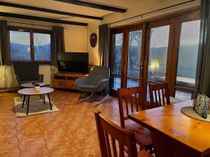een woonkamer met een televisie en een tafel en stoelen bij Chata v Kamenném Přívozu in Kamenný Přívoz