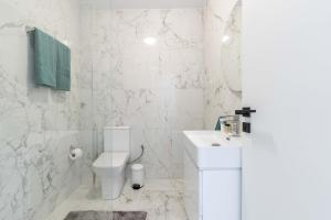 um banheiro branco com vaso sanitário e pia em Arcade Apartments 1st floor em Volos mais 7 fotografias