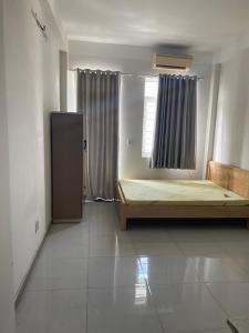 een lege kamer met een bed en een raam bij Không có tên in Ho Chi Minh-stad