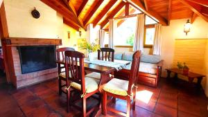 a dining room with a table and a fireplace at Taiquen Apart Hotel in San Martín de los Andes +49 photos