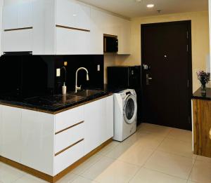 a kitchen with a sink and a washing machine at The Lume Studio - Tresor D4 in Ho Chi Minh City