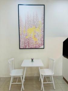 a table and two chairs and a painting on a wall at The Lume Studio - Tresor D4 in Ho Chi Minh City +4 photos