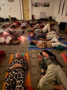 a group of people laying on mats in a room at Happy Homes by Yoga & Smiles, Upper Tapovan in Rishīkesh