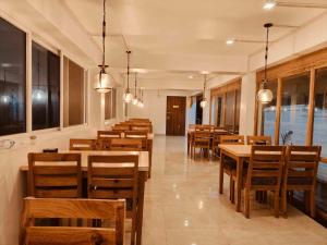 Un comedor con mesas y sillas de madera. en Hotel Sonam, en Dhulikhel