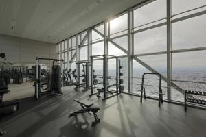 a gym with cardio equipment in a building with windows at Park Hyatt Tokyo in Tokyo