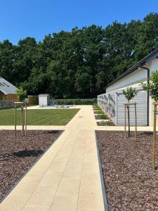 a walkway with two trees in a yard at Mamma Mia Park in Łukęcin