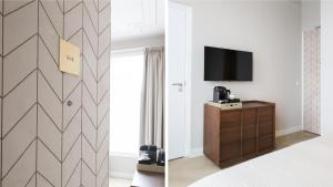 a bedroom with a tv and a room with a dresser at Dam Residence Boutique Hotel Amsterdam - Zaandam in Zaandam