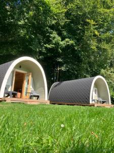 Camping het Bosbad في إميلورتْ: مبنيان ذوا قباب مع كراسي في العشب