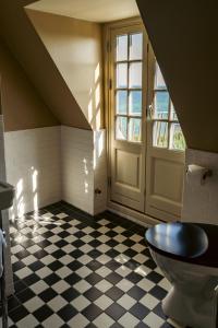 a bathroom with a toilet and a checkered floor at Helenekilde Badehotel in Tisvildeleje