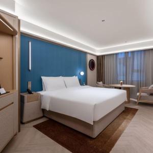 Postel nebo postele na pokoji v ubytování Orange Crystal Qingdao Taidong Pedestrian Street Yan'an Third Road Hotel