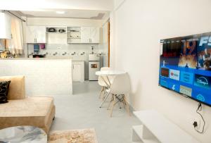 a living room with a table and a kitchen at Amno Elite Suites in Naivasha