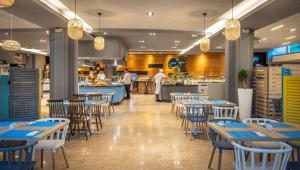 a restaurant with tables and chairs and a kitchen at Sunny Porec by Valamar in Poreč +34 photos
