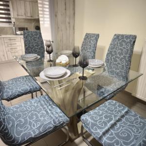 una mesa de cristal con sillas azules y un comedor en Luxury Apartment on Eleutherias Sq 50m from Metro, en Pireo