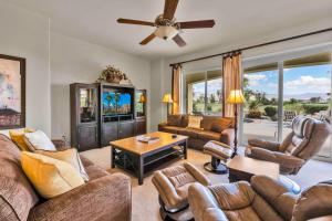 een woonkamer met lederen meubels en een plafondventilator bij Santa Monica in Myoma